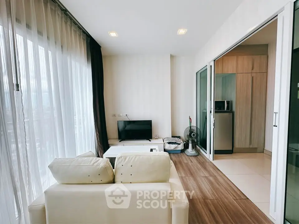 Modern living room with open layout and sleek kitchen in a stylish apartment.