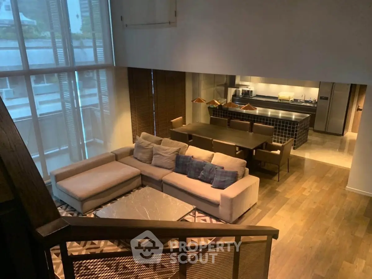 Luxurious open-plan living room with modern kitchen and stylish decor in a high-end apartment.