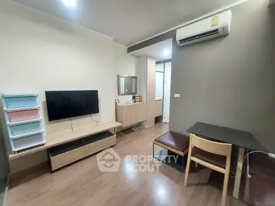 Modern living room with TV, air conditioning, and stylish furniture in cozy apartment.