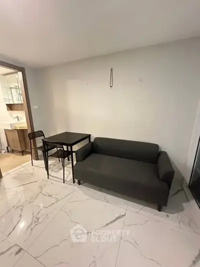 Modern living room with sleek sofa and dining set on marble flooring
