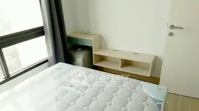 Modern bedroom with large window and minimalist furniture, perfect for urban living.