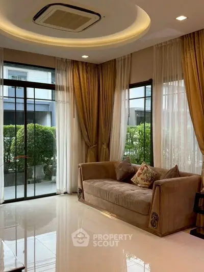 Elegant living room with large windows and plush sofa, offering a serene garden view.