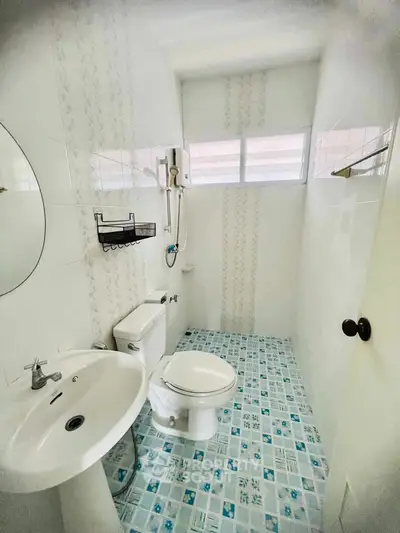 Compact bathroom with modern fixtures and patterned tile flooring.