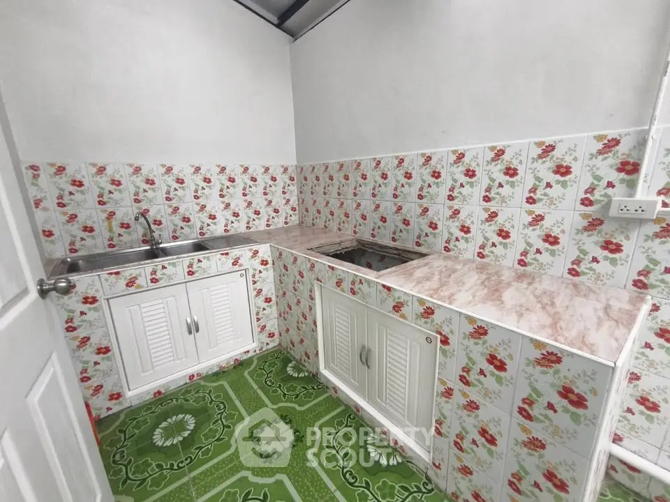 Charming kitchen with floral tile design and green patterned floor