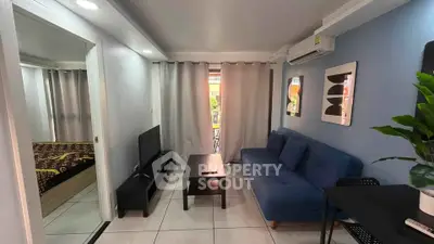 Modern living room with blue sofa, TV, and stylish decor in a cozy apartment setting.