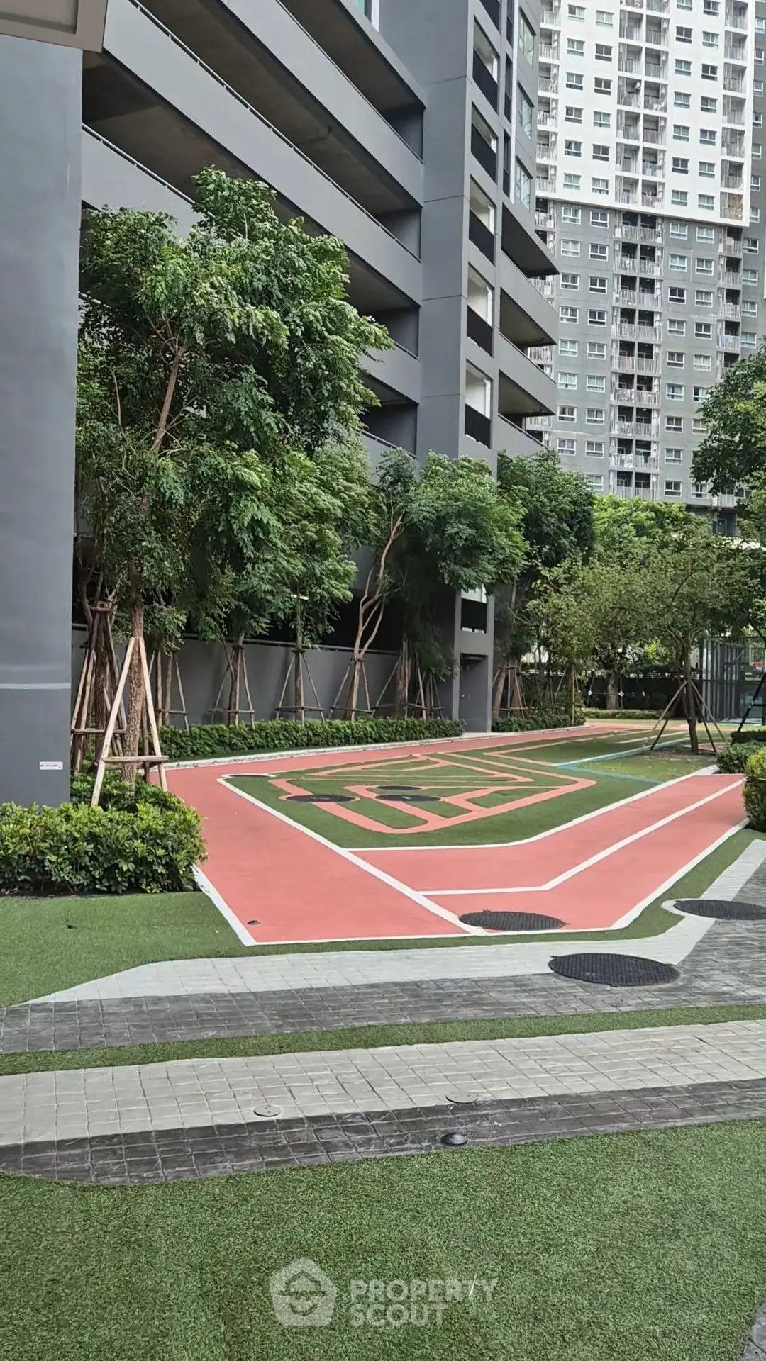Modern residential building with landscaped outdoor area and jogging track