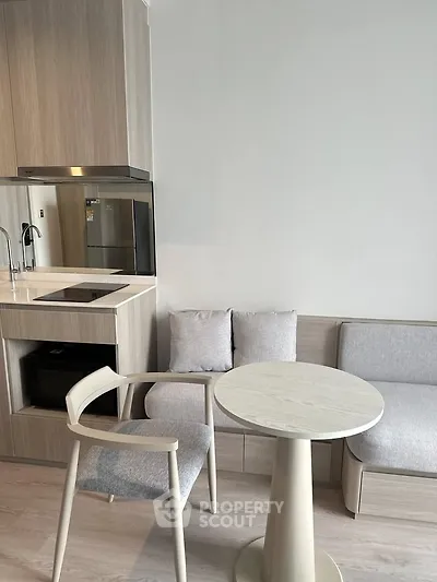 Modern kitchen with cozy dining area and sleek appliances in a stylish apartment.