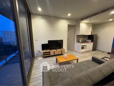 Modern living room with sleek design, large windows, and compact kitchen area, perfect for urban living.