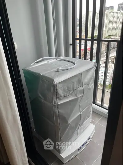Compact balcony with washing machine and city view, ideal for urban living.