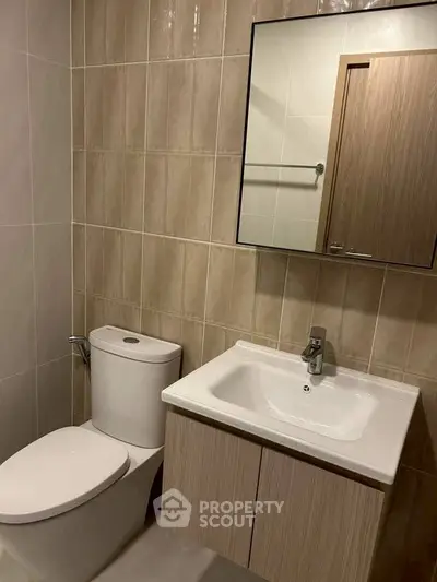 Modern bathroom with sleek fixtures and neutral tile design, perfect for a contemporary home.