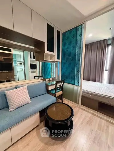 Modern compact living room with stylish decor and adjacent bedroom view