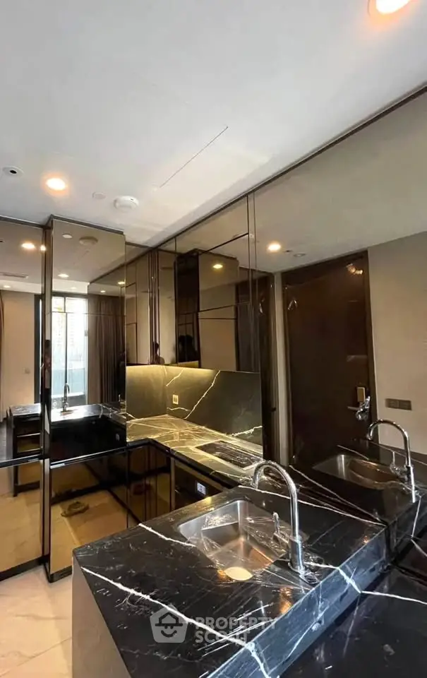 Luxurious modern kitchen with sleek black marble countertops and mirrored cabinets