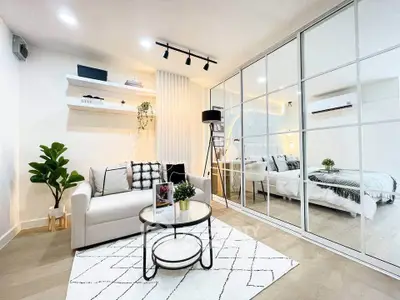 Modern living room with stylish decor and mirrored wardrobe