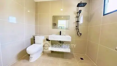Modern bathroom with sleek fixtures and neutral tiles, featuring a rain shower and floating vanity.