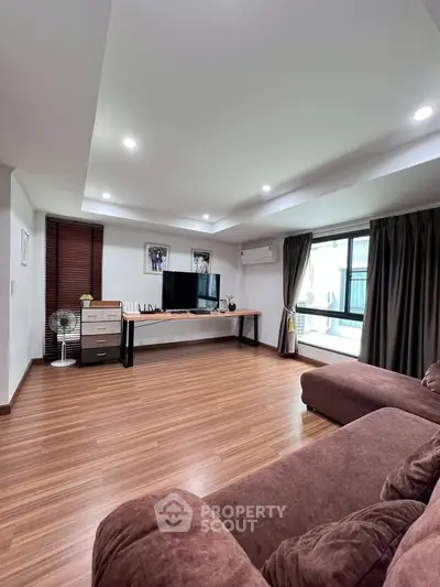 Spacious living room with modern decor and large windows for natural light.
