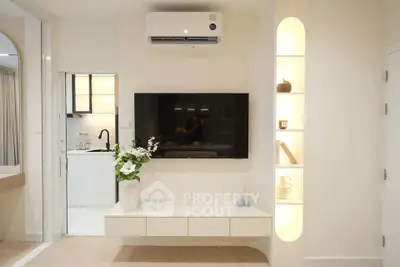 Modern living room with wall-mounted TV and built-in shelves in a stylish apartment.