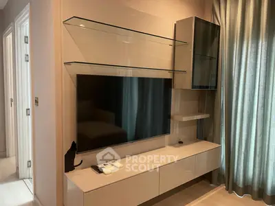 Modern living room with sleek TV unit and glass shelves, perfect for stylish urban living.