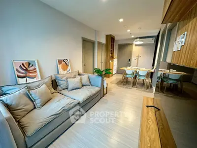 Modern living room with cozy sofa and stylish dining area in open layout apartment.