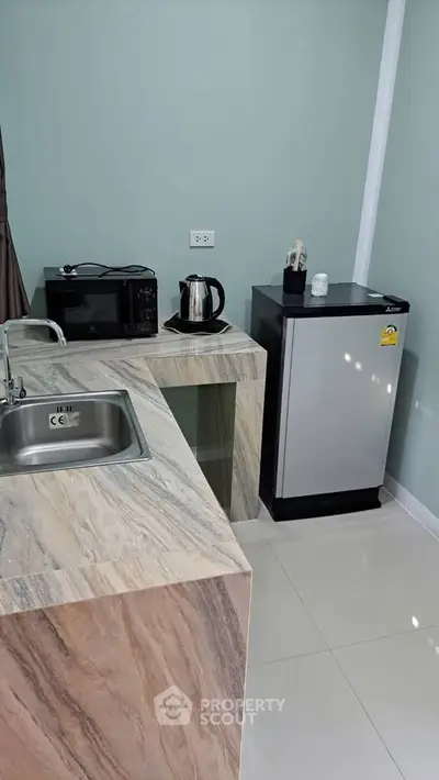 Modern kitchen with marble countertops and compact appliances