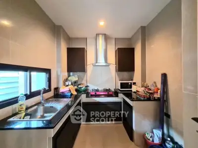 Modern kitchen with sleek cabinets and gas stove in a cozy home setting.
