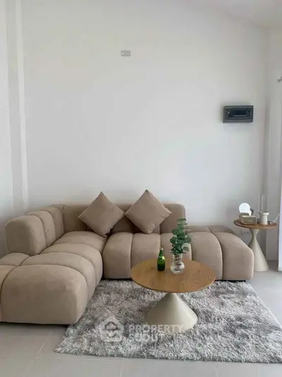 Modern living room with stylish beige sofa and chic coffee table on plush rug.