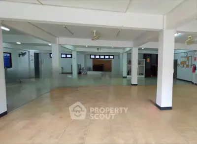 Spacious open-plan interior with tiled flooring and ample natural light, ideal for versatile use.