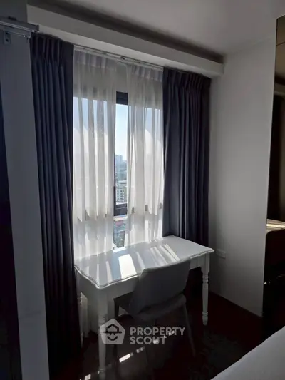 Cozy study nook with a view, featuring a white desk and chair by the window.