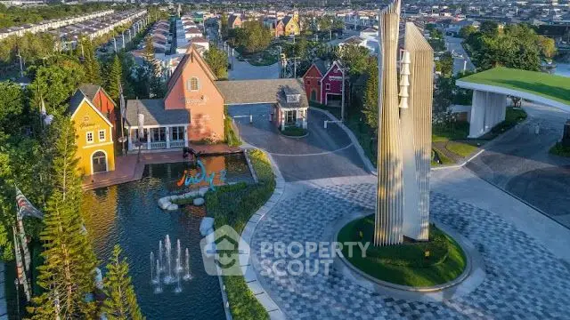 Stunning aerial view of modern residential community with iconic architectural landmark and lush greenery.