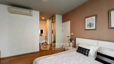 Modern bedroom with stylish decor and wooden flooring, featuring a cozy bed and elegant wall art.