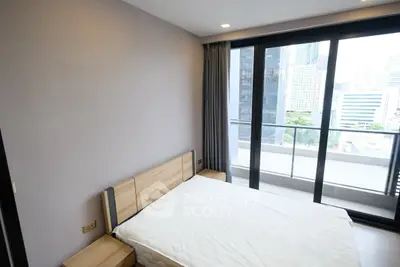 Modern bedroom with city view and large windows in urban apartment
