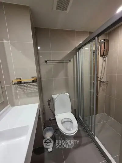Modern bathroom with sleek design, featuring a glass-enclosed shower and contemporary fixtures.