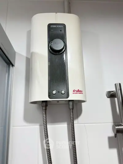 Modern bathroom with sleek water heater installed on white tiled wall.