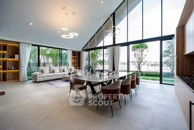 Spacious modern living room with large windows and elegant dining area