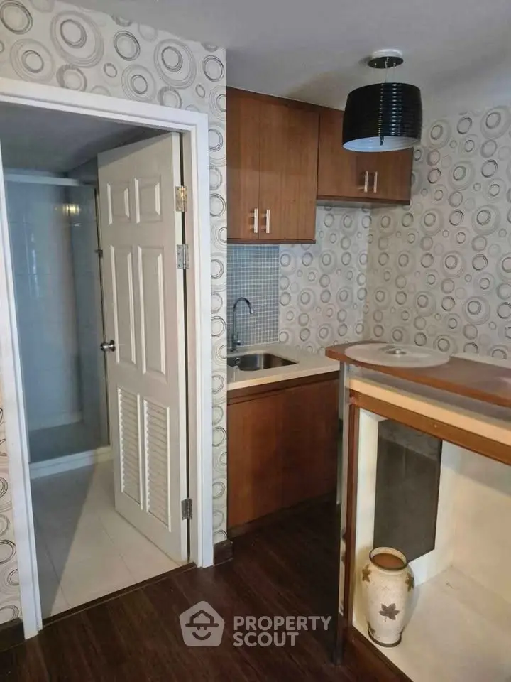 Cozy kitchenette with wooden cabinets and modern wallpaper design