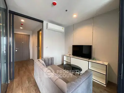 Modern living room with sleek furniture and wooden flooring in a stylish apartment.