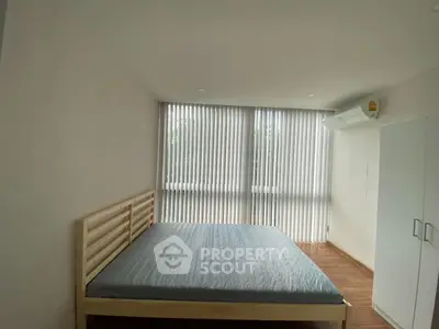 Spacious bedroom with large windows and modern air conditioning unit.