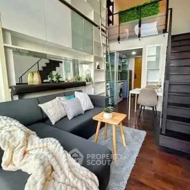 Modern loft-style living room with sleek staircase and cozy decor
