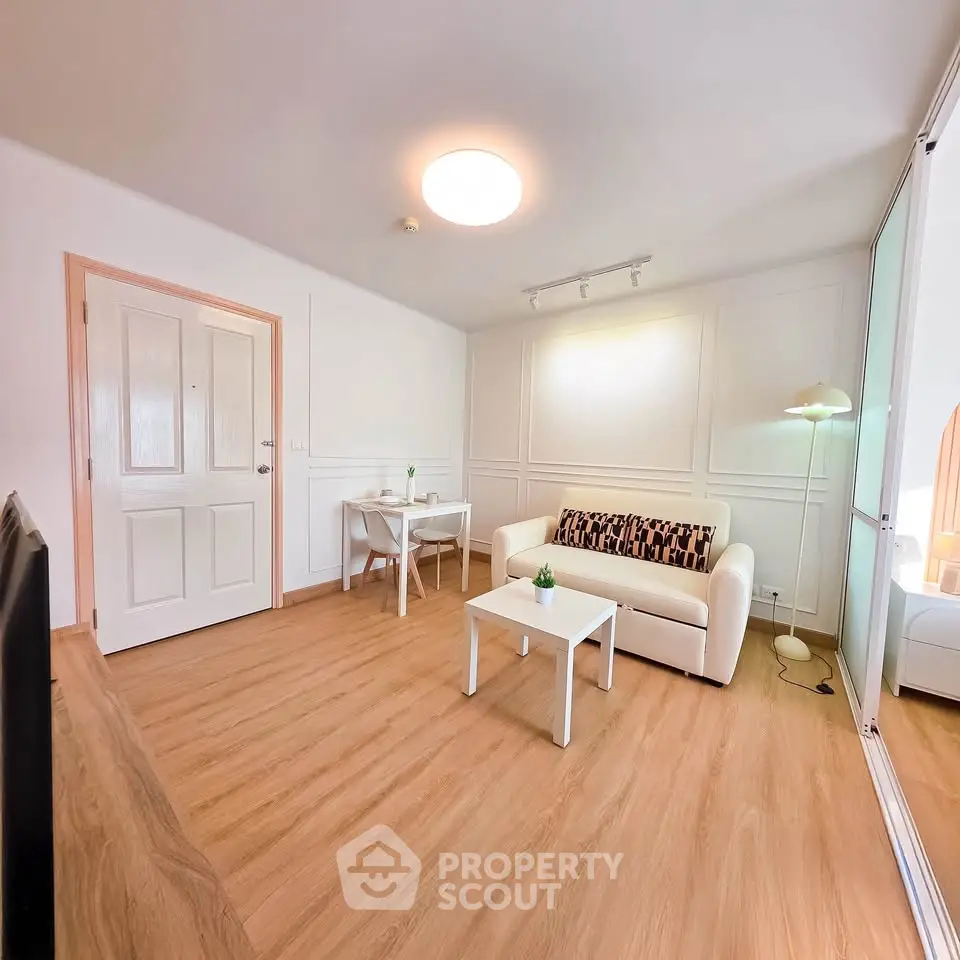 Modern living room with stylish decor and wooden flooring, featuring a cozy sofa and elegant lighting.