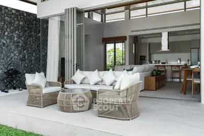 Luxurious open-plan living area with modern outdoor seating and sleek kitchen view.