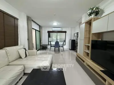 Spacious modern living room with sleek furniture and dining area