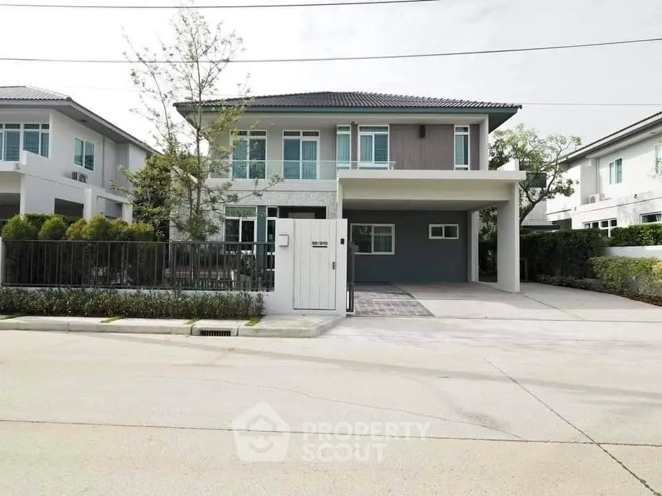Modern two-story house with driveway and landscaped front yard in a suburban neighborhood.