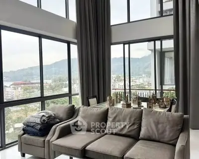Luxurious living room with panoramic city and mountain views, featuring elegant decor and floor-to-ceiling windows.
