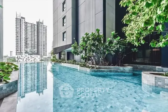 Luxurious modern apartment building with stunning pool and lush greenery.