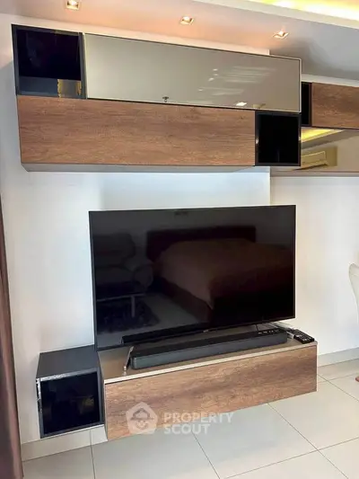 Modern living room with sleek TV unit and stylish wood accents.