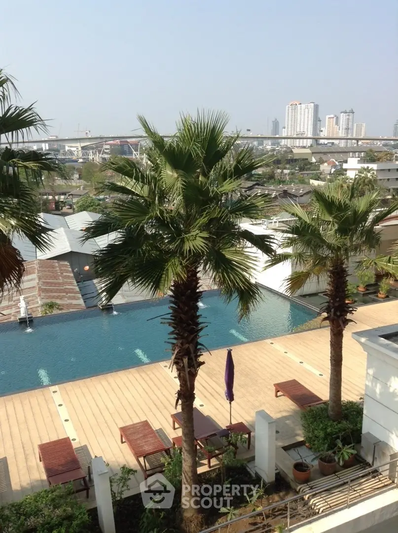 Luxurious rooftop pool with stunning city views and palm trees, perfect for relaxation and leisure.