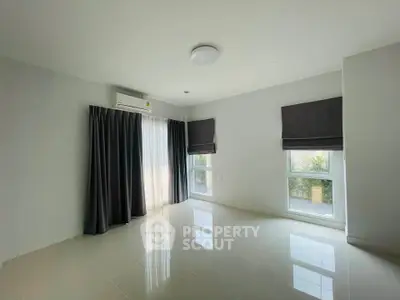 Spacious unfurnished room with large windows and air conditioning, perfect for customization.