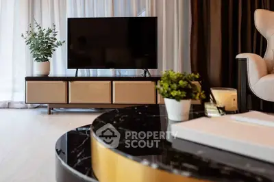Modern living room with stylish furniture and large TV, perfect for relaxation.