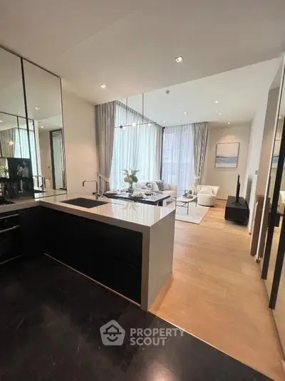 Modern open-layout kitchen and living room with sleek design and natural light.