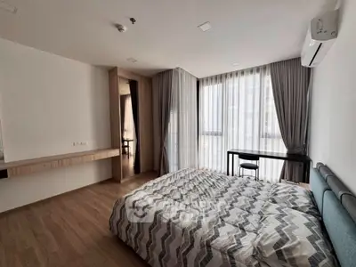 Modern bedroom with large windows and stylish decor in a contemporary apartment.