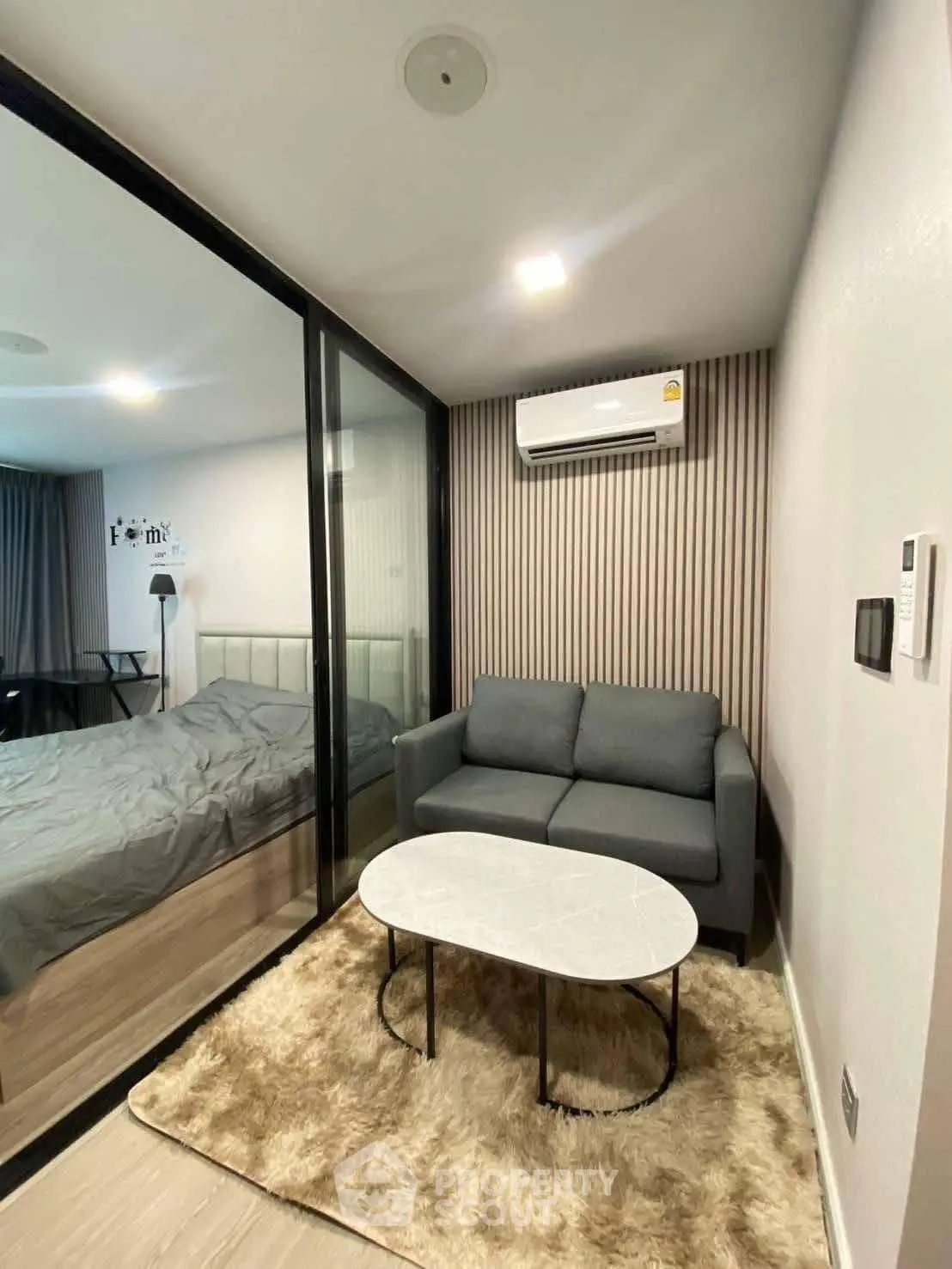 Modern compact living room with glass partition and cozy decor